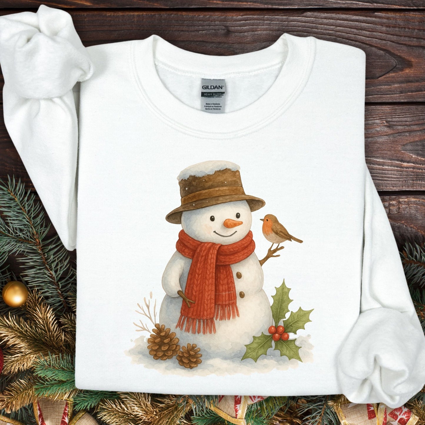 White Gildan 18000 sweatshirt with a watercolor snowman, sparrow, holly, and pinecones.