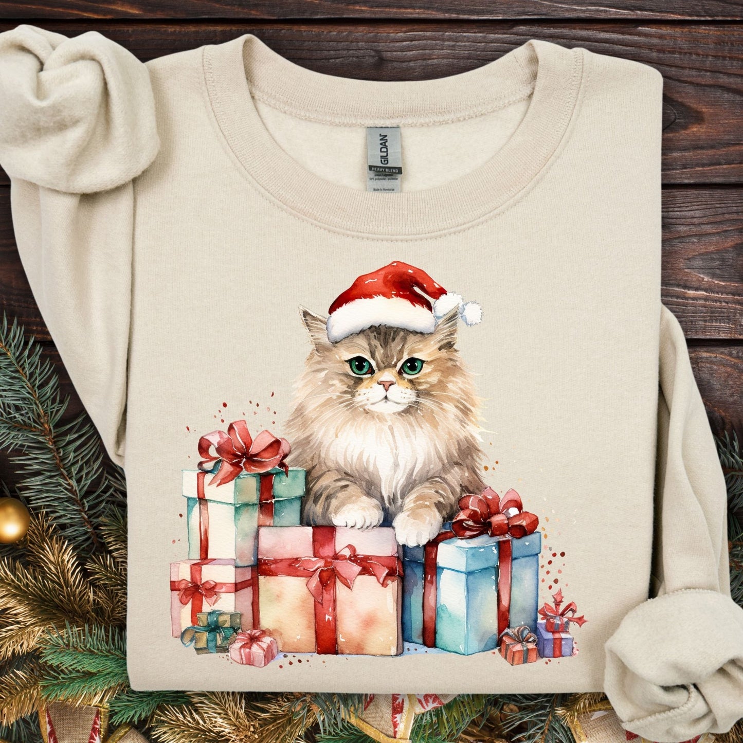 Sand Gildan sweatshirt with a watercolor cat in a Santa hat on colorful Christmas presents.