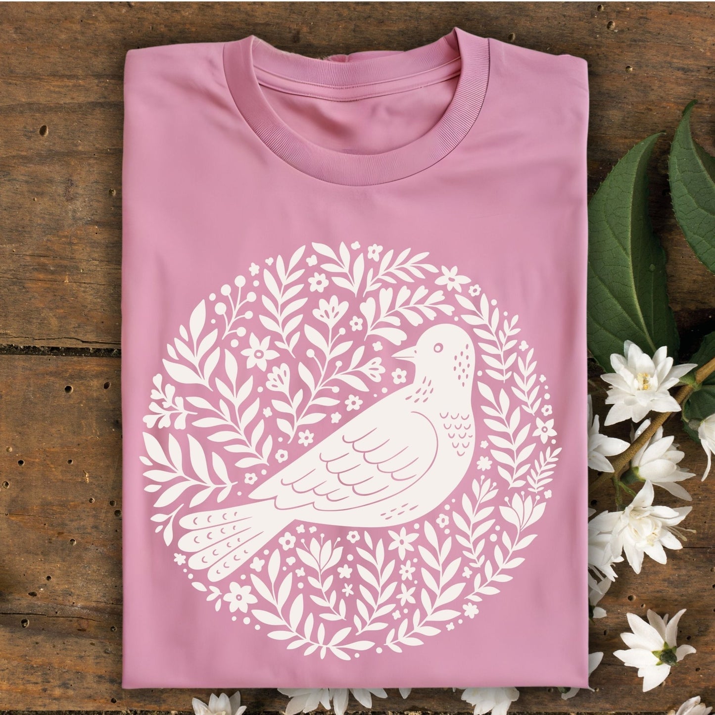 Azalea pink S-size t-shirt with a white Scandinavian bird and floral wreath design.