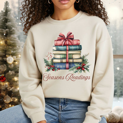 Beige unisex sweatshirt with a watercolor stack of vintage Christmas books, holly, and "Seasons Readings.
