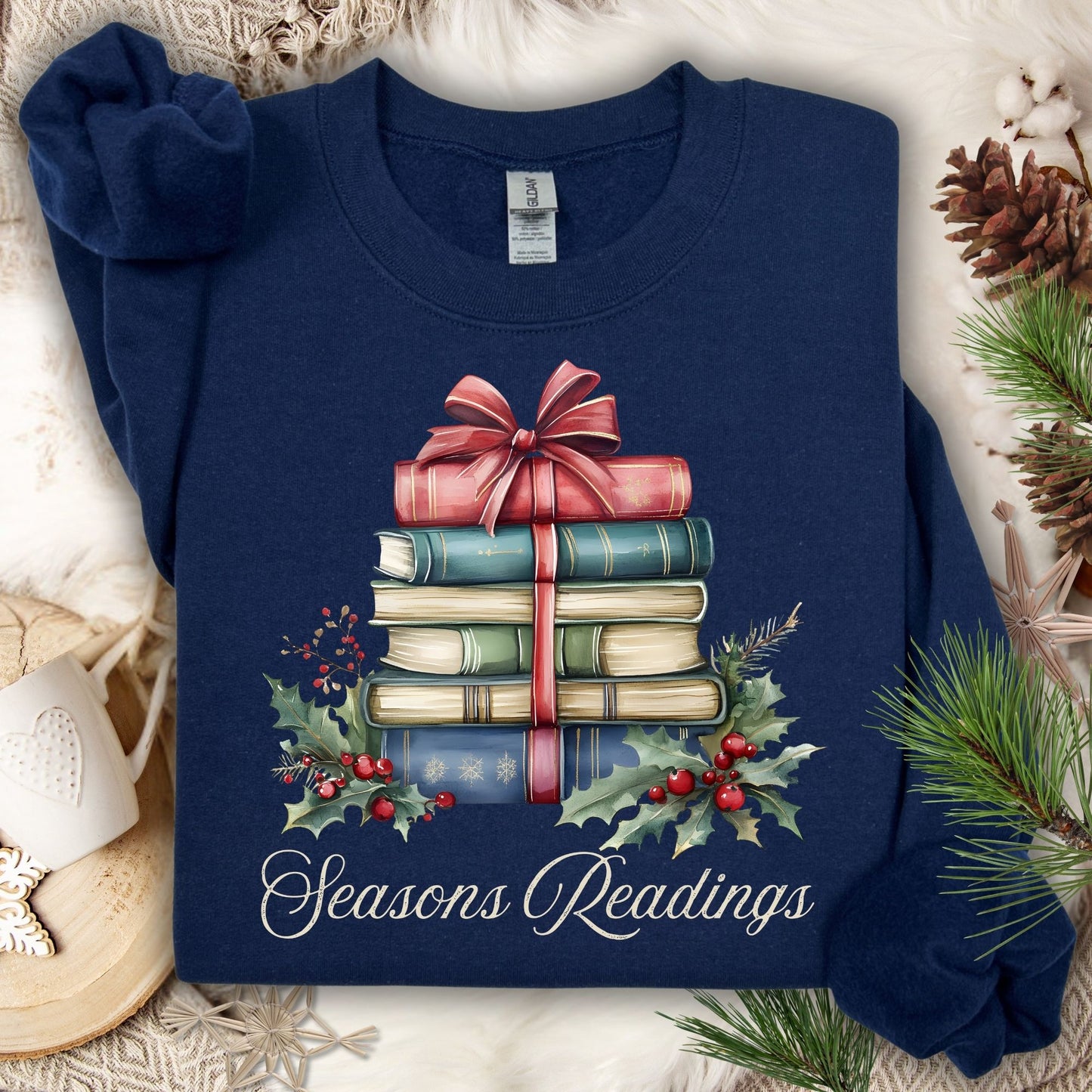 Navy fleece sweatshirt with watercolor vintage Christmas books, holly, and "Seasons Readings" text.