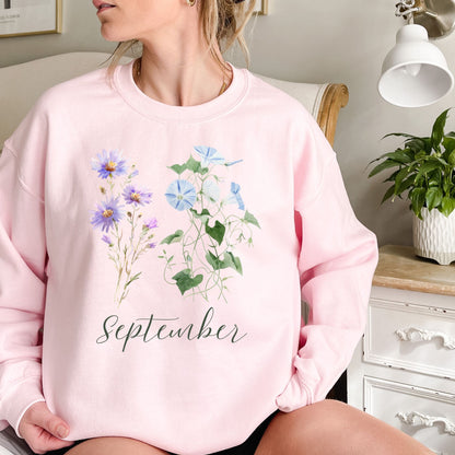 Pink crewneck sweatshirt with watercolor morning glory and aster blooms, plus "September" text.