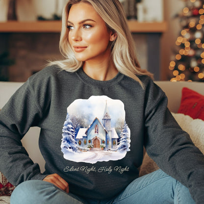 Blonde woman wearing a dark gray Gildan fleece sweatshirt with a snowy chapel design and "Silent Night, Holy Night" text.