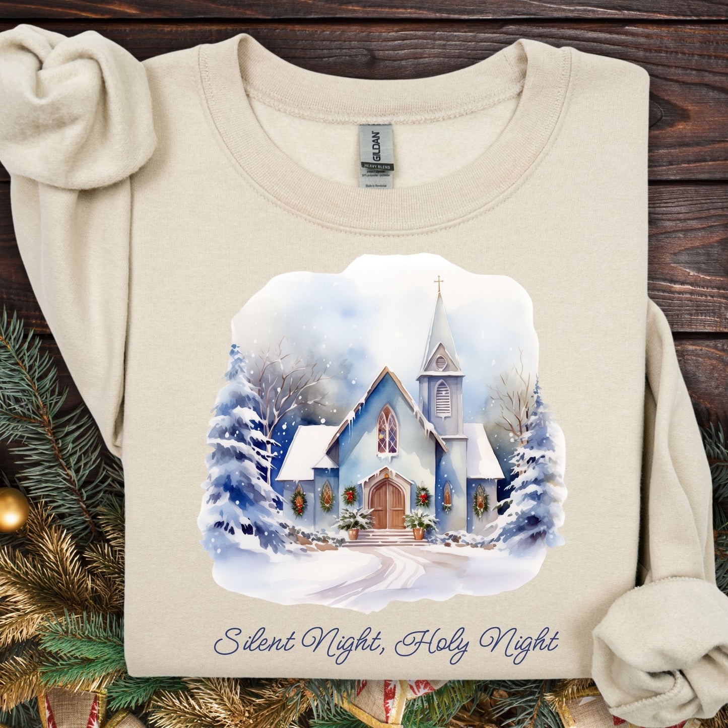 Beige Gildan fleece sweatshirt with a snowy country chapel, evergreen trees, and "Silent Night, Holy Night" text.