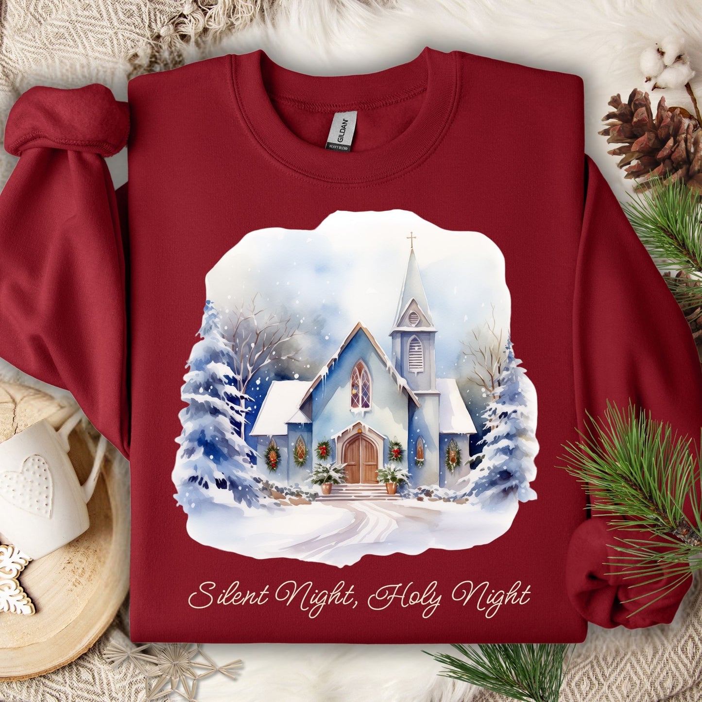 Cardinal Red Gildan fleece sweatshirt with a snowy country chapel design and "Silent Night, Holy Night" text.
