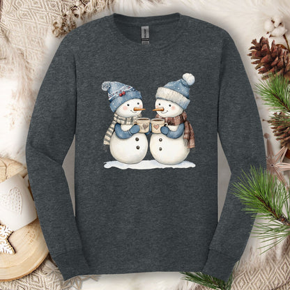 Dark Heather long sleeve tee with two snowpeople in blue hats and scarves drinking hot chocolate.