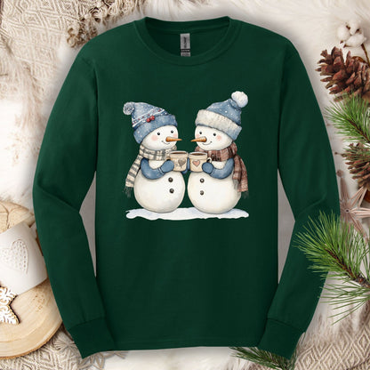 Forest Green long sleeve tee with two snowpeople in blue hats and scarves drinking hot chocolate.