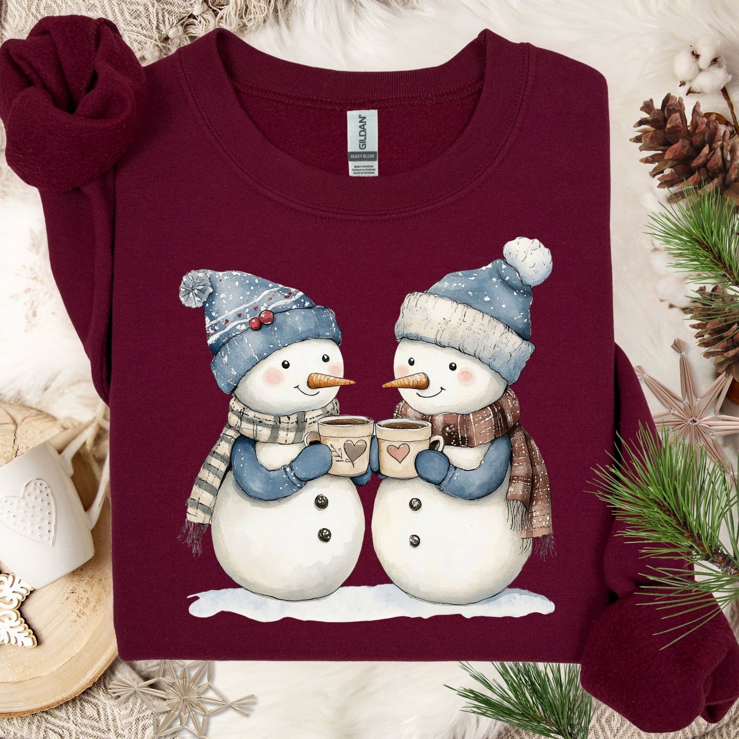 Maroon cotton-polyester sweatshirt with two snowpeople in blue hats and scarves, holding hot chocolate.