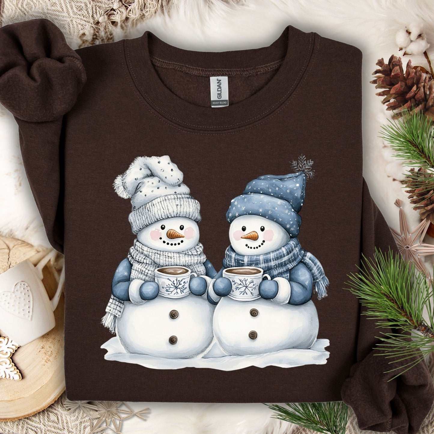 Dark Chocolate heavy blend sweatshirt with two snowpeople in blue hats and scarves holding hot chocolate.