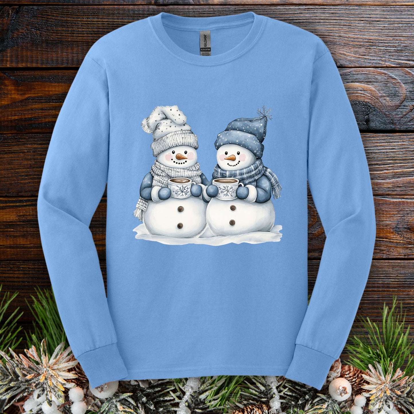 Carolina Blue long-sleeve tee with two hand-painted snowmen holding hot chocolate mugs.