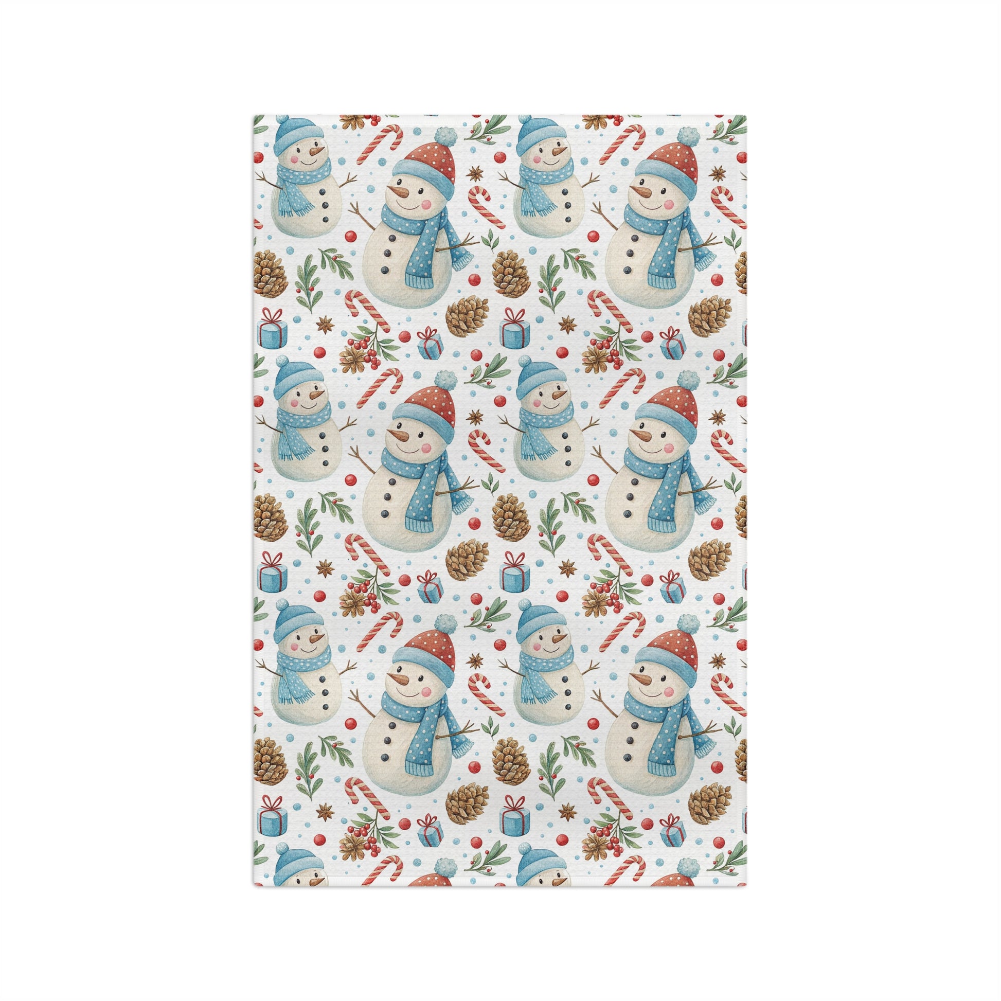 Holiday microfiber tea towel with a pattern of snowmen, candy canes, pine cones, and holly on white.