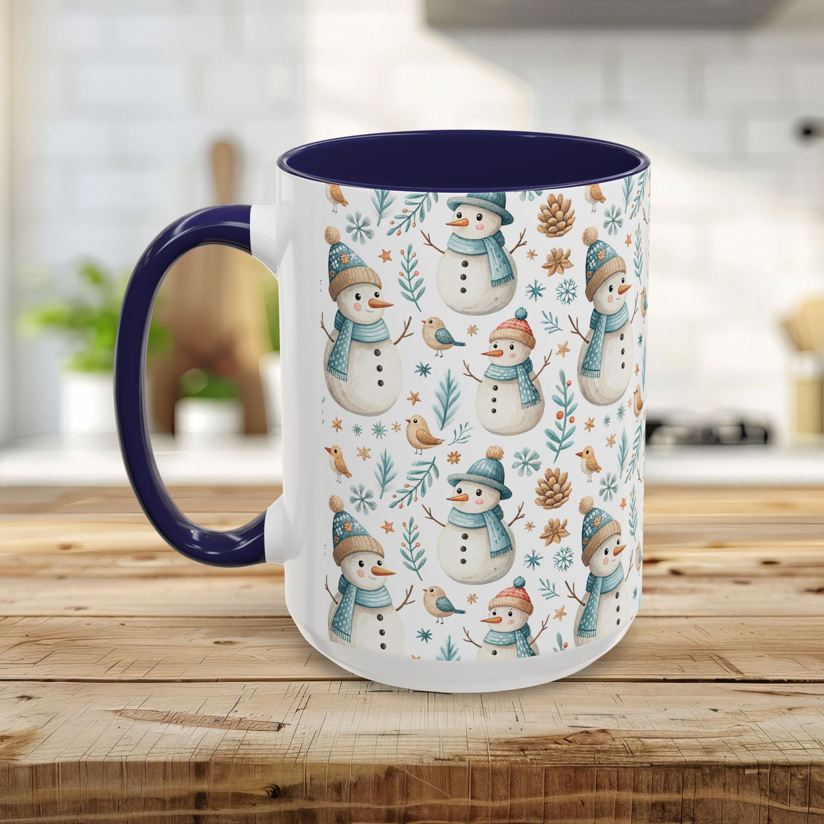 White ceramic mug with watercolor snowmen, birds, and pinecones, featuring a navy blue interior and handle.