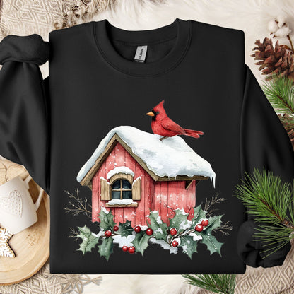 Black Gildan sweatshirt with a watercolor red cardinal on a snow-covered birdhouse, holly, and berries.