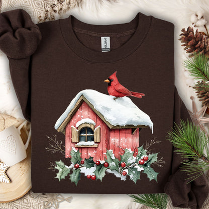 Dark chocolate Gildan fleece sweatshirt with a watercolor cardinal on a snowy birdhouse, holly, and berries.