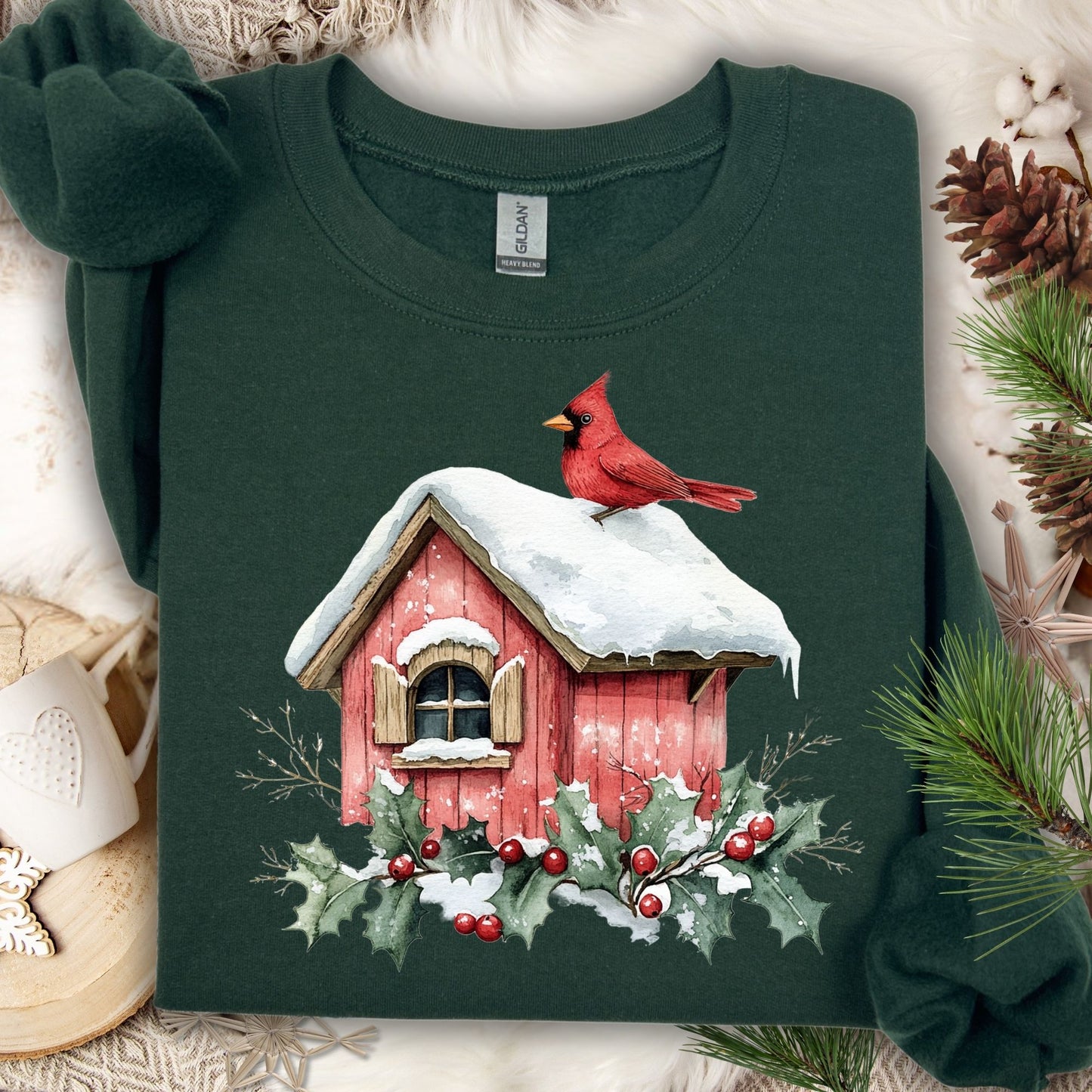 Forest Green Gildan sweatshirt with a watercolor red cardinal on a snowy birdhouse, holly, and berries.