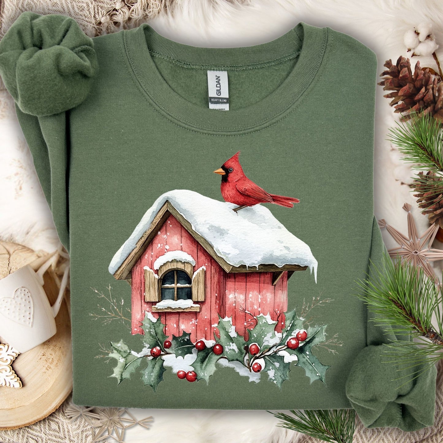 Military Green Gildan sweatshirt with a watercolor red cardinal on a snow-covered birdhouse and holly.