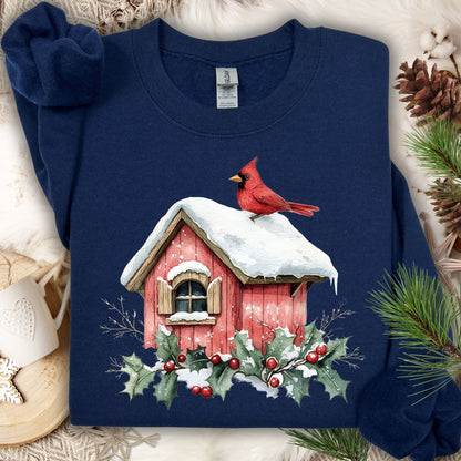Navy Gildan fleece sweatshirt with a watercolor red cardinal on a snow-covered birdhouse, holly, and berries.