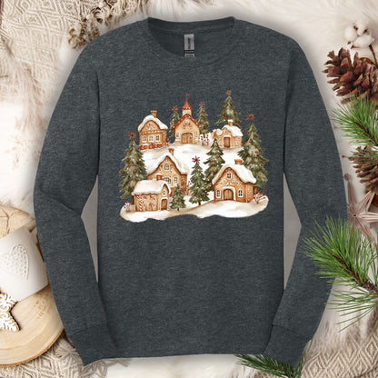 Dark heather long sleeve tee with a watercolor snowy gingerbread village and evergreens.