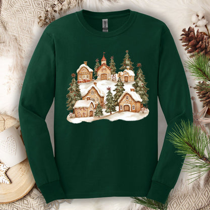 Forest Green long sleeve tee with a watercolor snowy gingerbread village and evergreens.