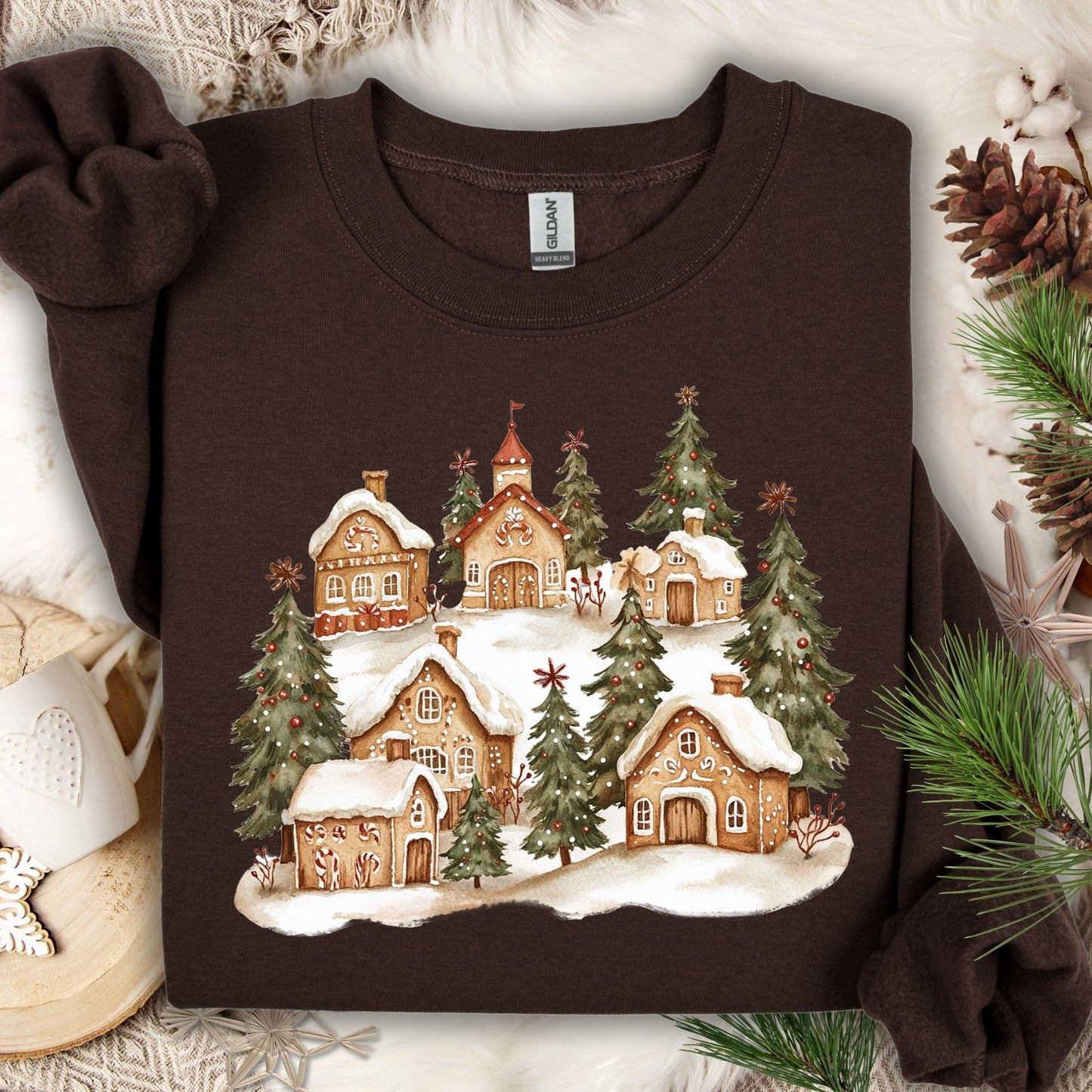 Dark Chocolate Gildan 18000 sweatshirt with a watercolor snowy gingerbread village and evergreens.