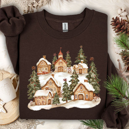 Dark Chocolate Gildan 18000 sweatshirt with a watercolor snowy gingerbread village and evergreens.