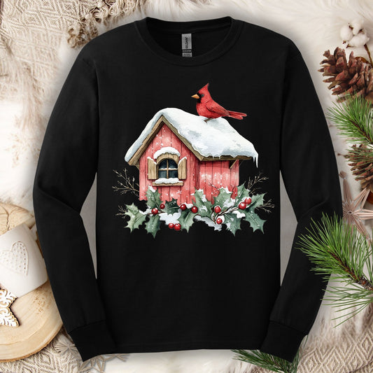Black Gildan long sleeve tee with a watercolor red cardinal on a snowy birdhouse with holly.