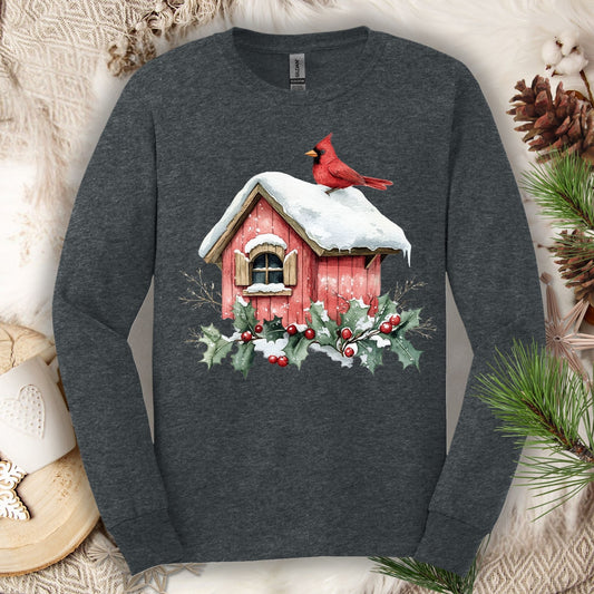 Dark Heather long sleeve tee with a watercolor red cardinal on a snowy rustic birdhouse with holly.