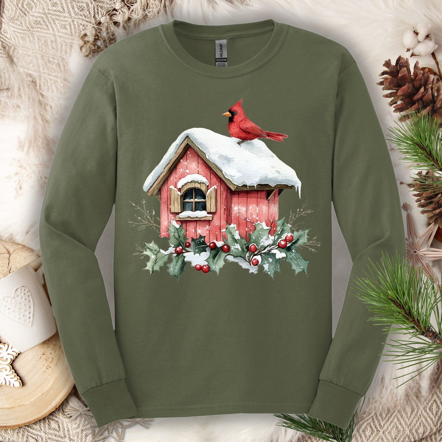 Military Green long sleeve tee with a watercolor red cardinal on a snowy birdhouse with holly.