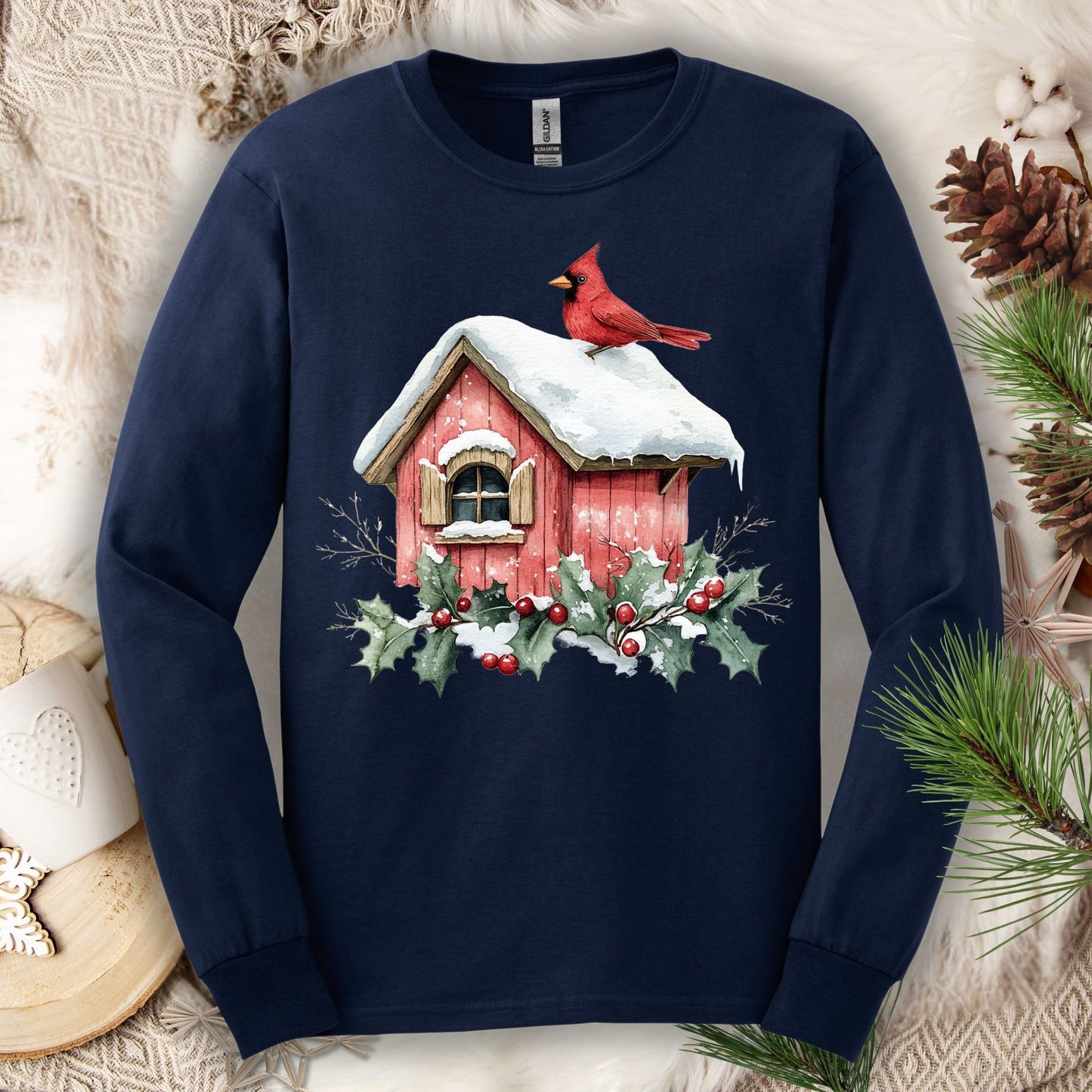 Navy long sleeve tee with a watercolor red cardinal on a snowy rustic birdhouse with holly.
