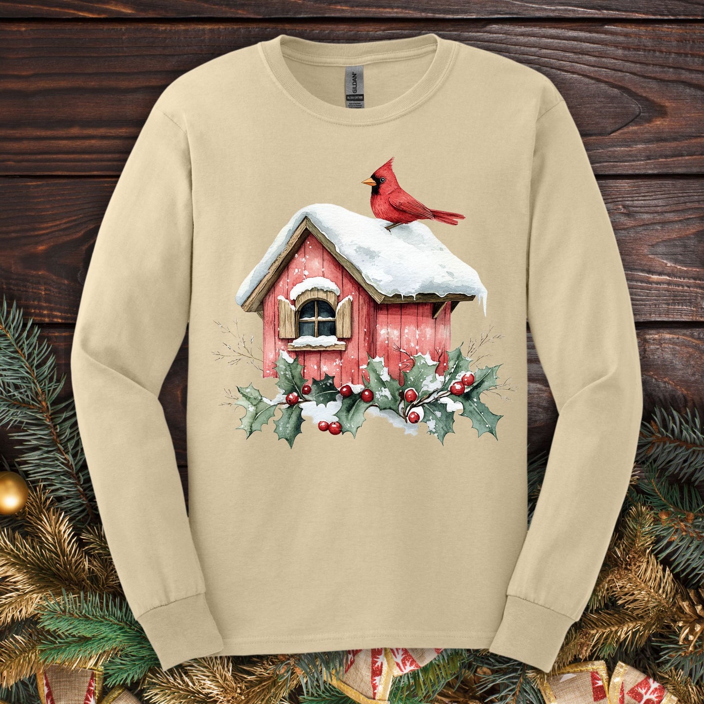 Sand Gildan Softstyle long sleeve tee with watercolor red cardinal on snowy birdhouse, holly, and berries.
