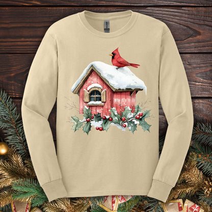 Sand Gildan Softstyle long sleeve tee with watercolor red cardinal on snowy birdhouse, holly, and berries.