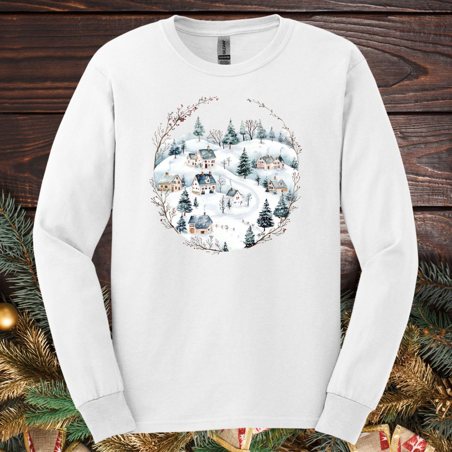 White Gildan Softstyle long sleeve tee with a watercolor folk-art snowy winter village design.