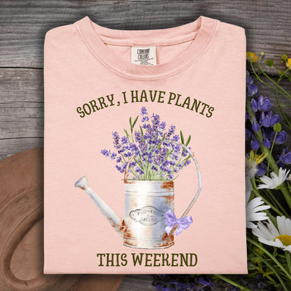 Peachy Comfort Colors t-shirt with "Sorry, I Have Plants This Weekend" and a vintage watering can with lavender.