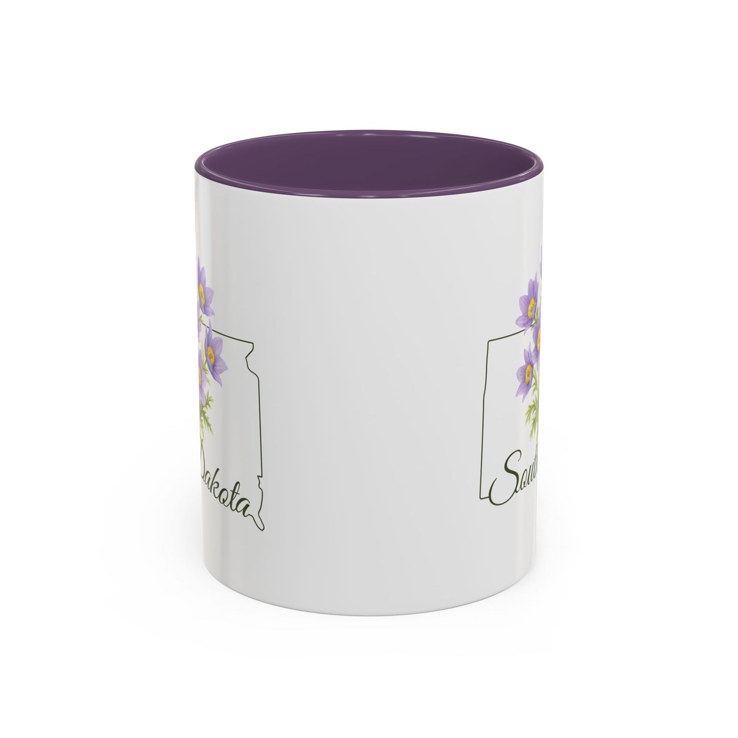 White ceramic mug with purple interior and handle, featuring a watercolor American Pasque flower and South Dakota outline.