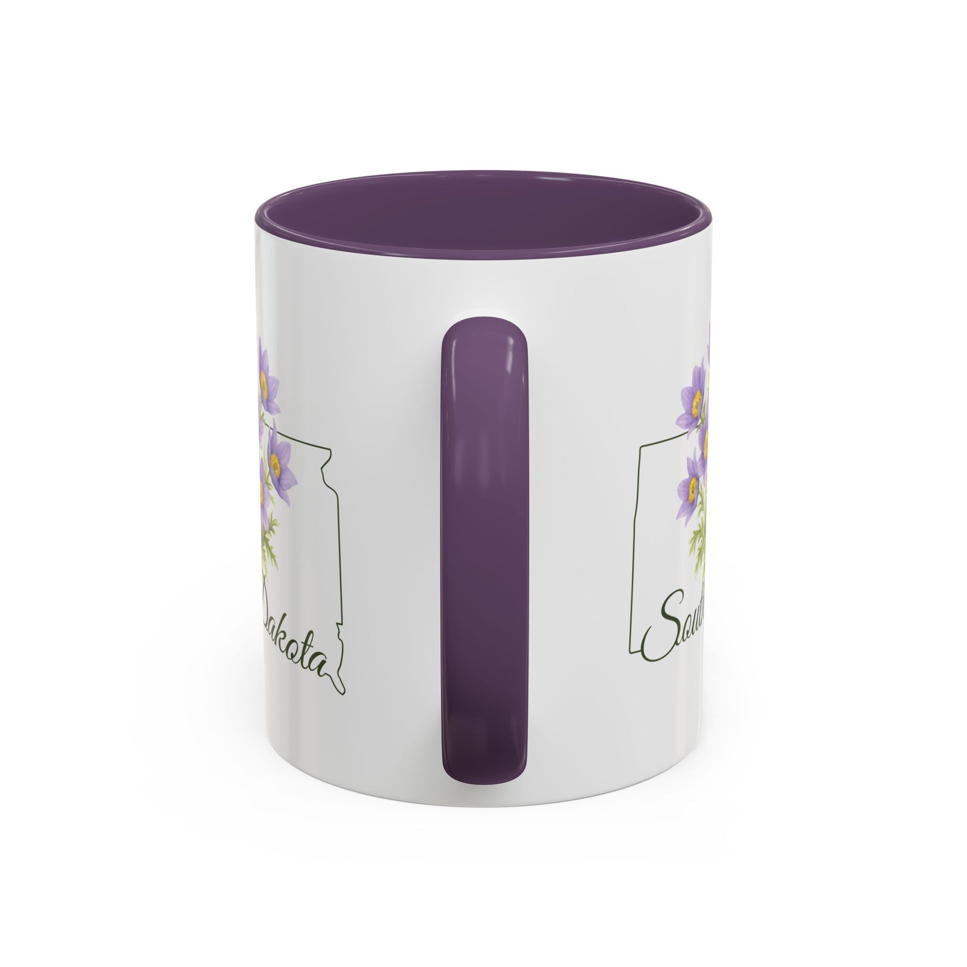 White ceramic mug with purple interior and handle, featuring a watercolor pasque flower and "South Dakota" script.