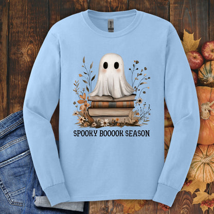 Light blue Gildan long sleeve tee with a ghost on books, fall wildflowers, and "SPOOKY BOOOOK SEASON" text.