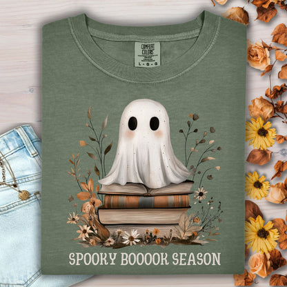 Moss green tee with a whimsical ghost on vintage books and "SPOOKY BOOOOK SEASON" text.