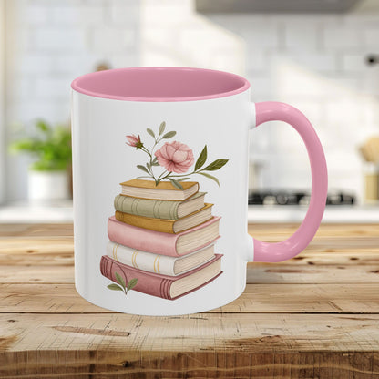 White 11oz ceramic mug with pink handle and interior, featuring a watercolor stack of books and floral accents.