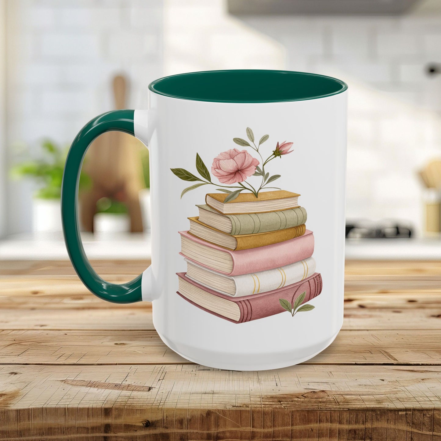 White ceramic mug with a green handle and interior, featuring a watercolor stack of books and pink floral accents.