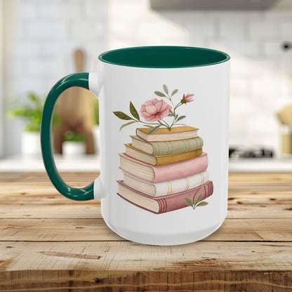 White ceramic mug with a green handle and interior, featuring a watercolor stack of books and pink floral accents.
