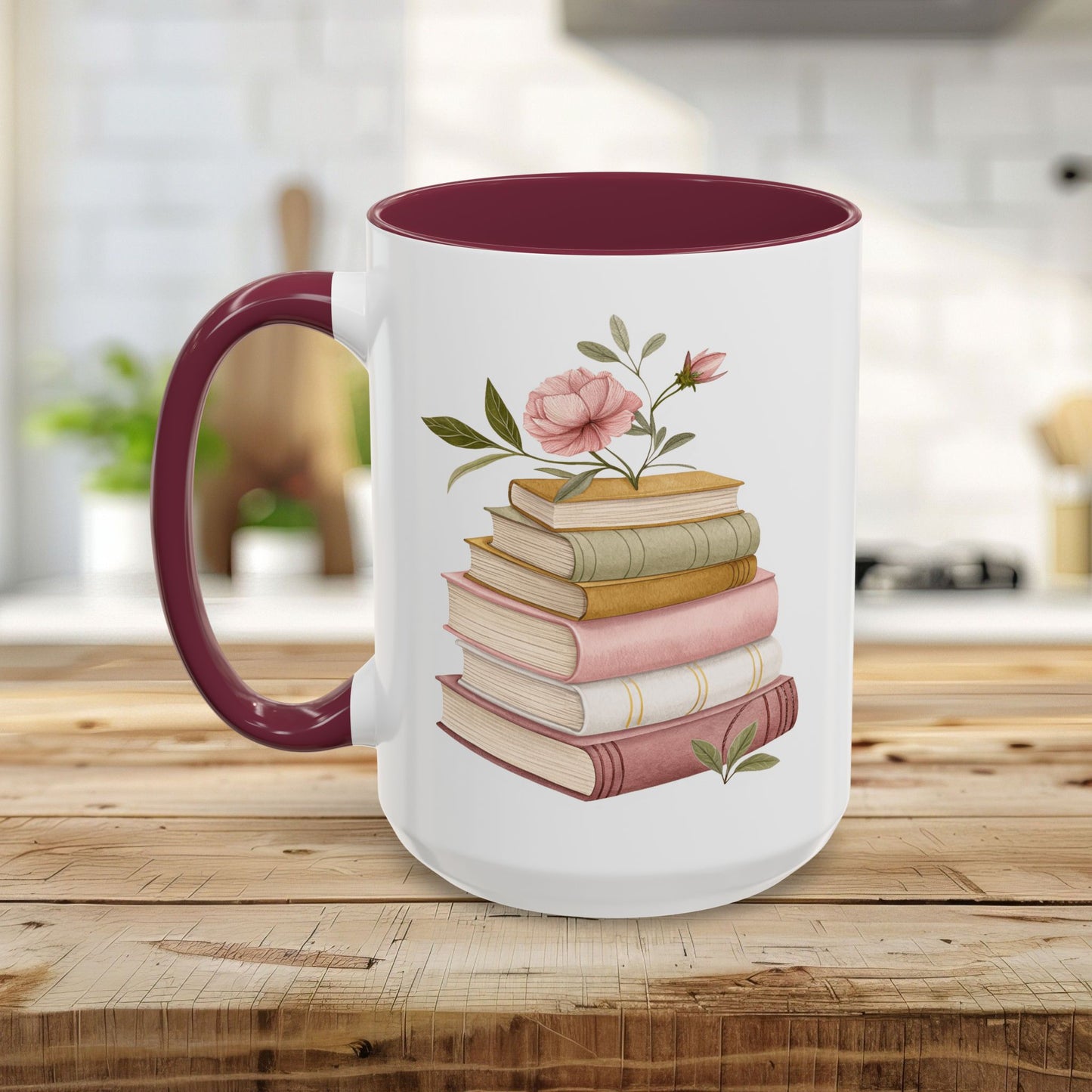 White ceramic mug with a maroon handle and interior, featuring a watercolor stack of books with pink floral accents.