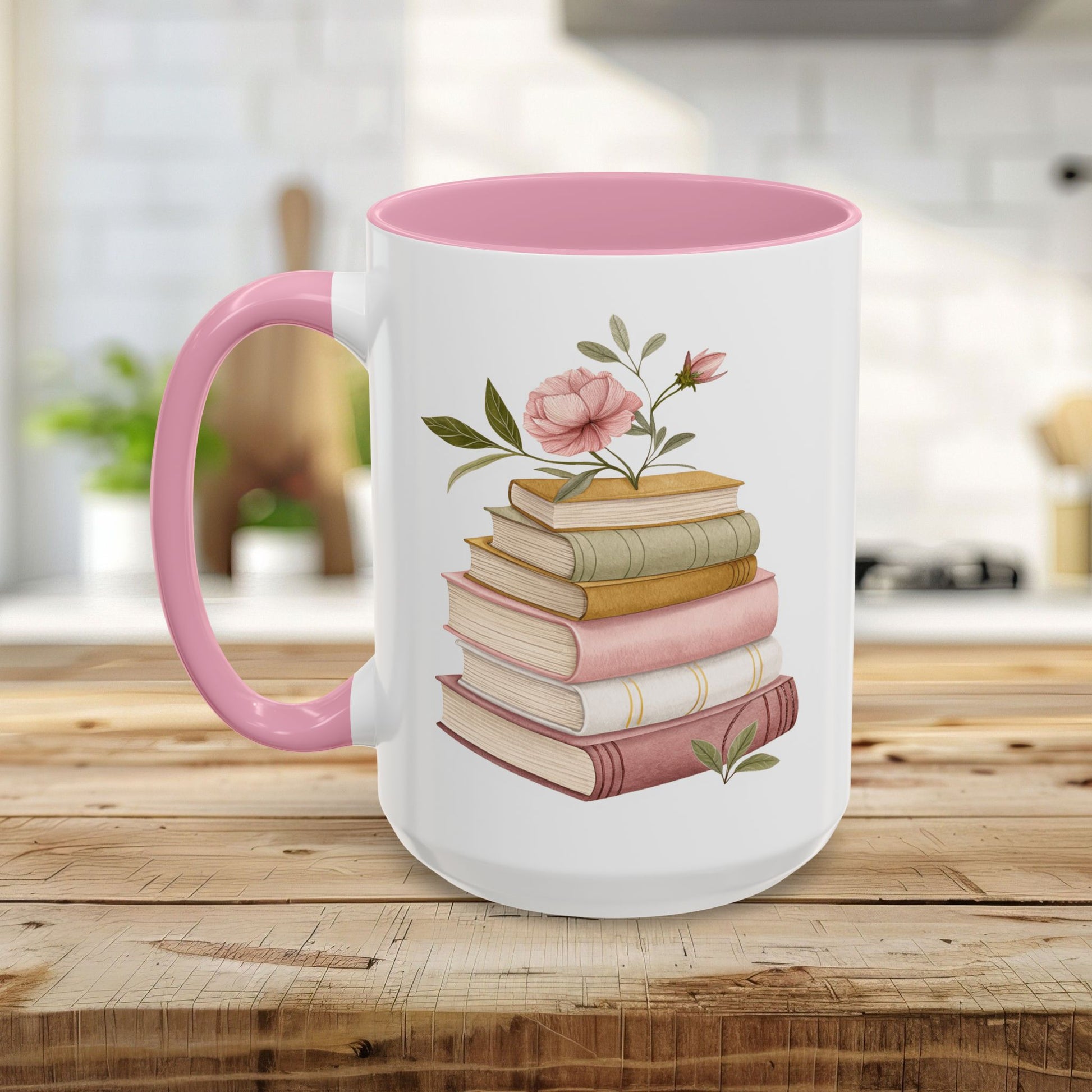 White ceramic mug with pink handle and interior, featuring a watercolor stack of books and floral accents.