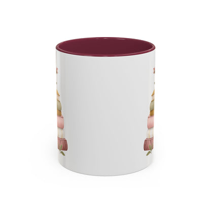 White ceramic mug with a maroon interior and handle, featuring a watercolor stack of books and floral accents.