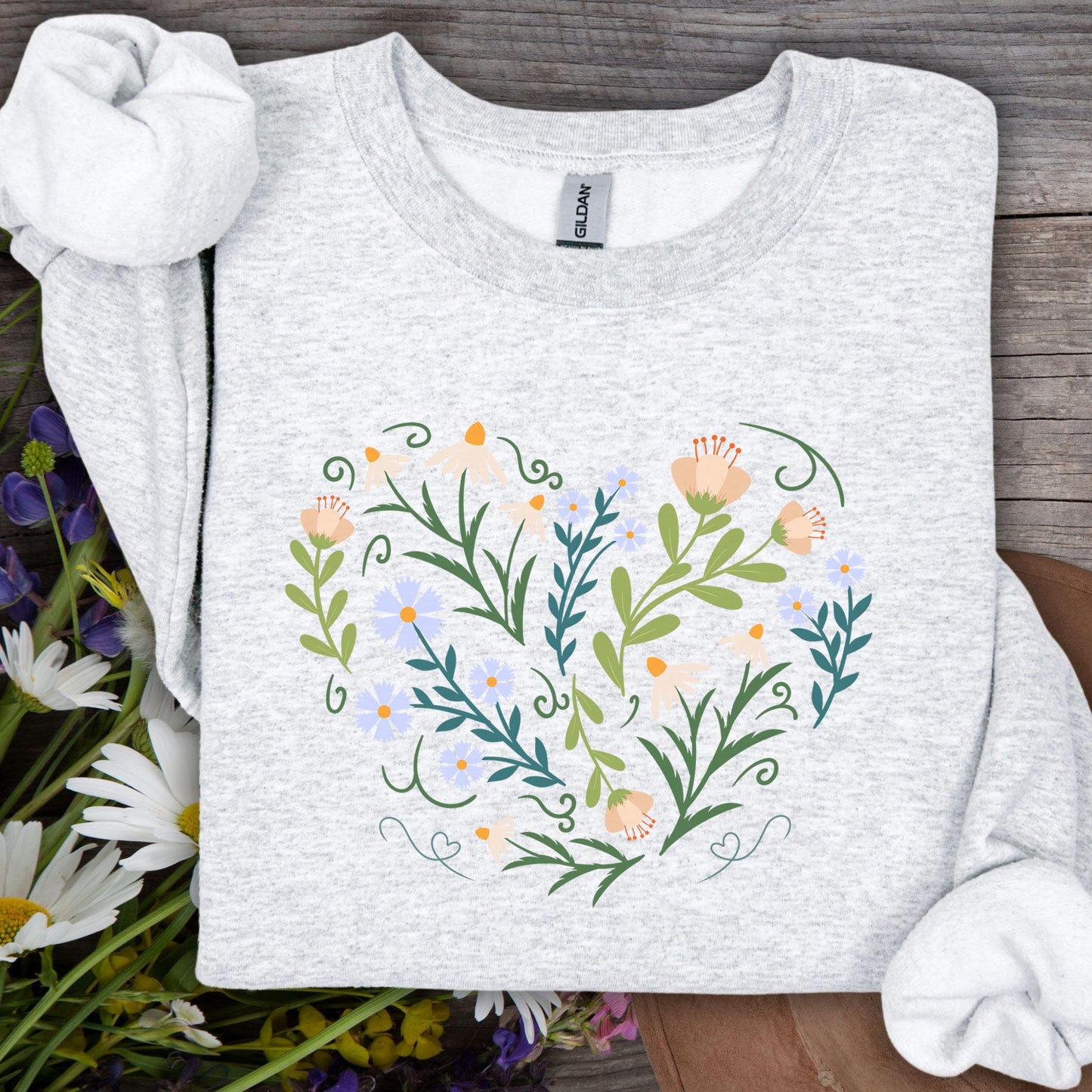 Ash gray sweatshirt with a heart-shaped floral design of daisies, tulips, and vines.