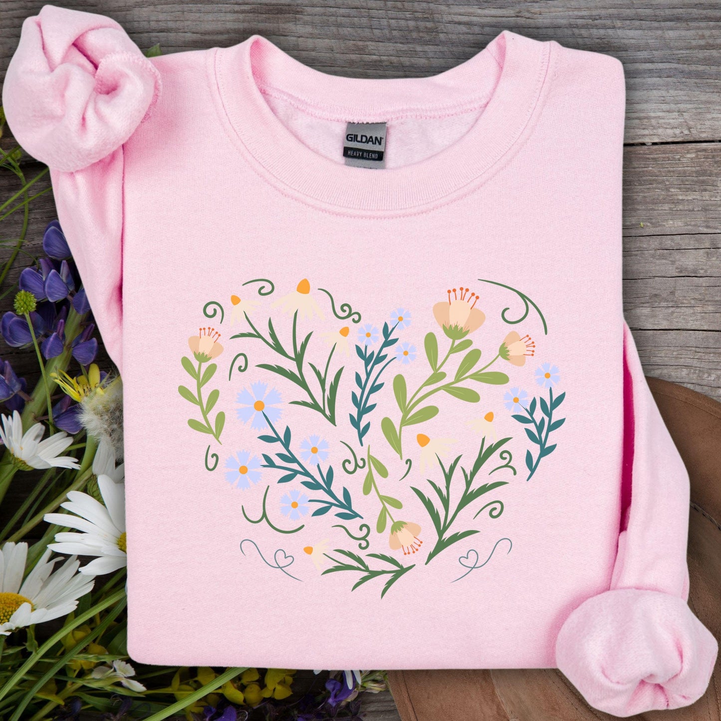 Light pink Gildan sweatshirt with a heart-shaped floral design of wildflowers, vines, and small hearts.