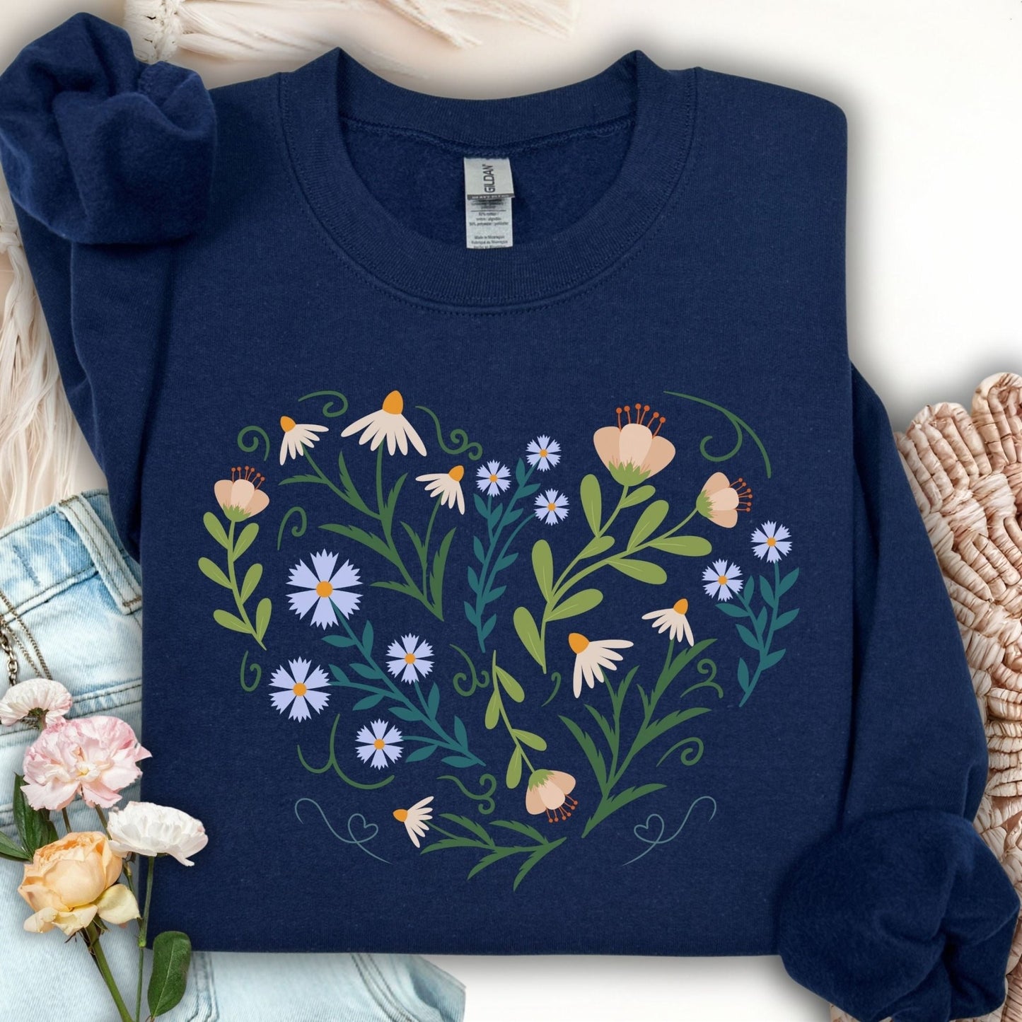 Navy sweatshirt with a heart-shaped floral design featuring daisies, tulips, and bell-shaped blooms.
