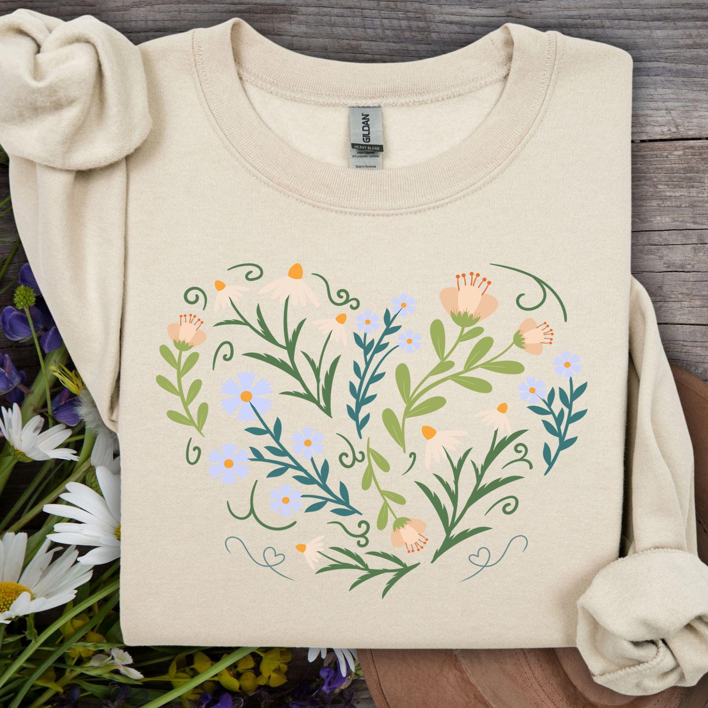 Sand sweatshirt with a heart-shaped botanical design of wildflowers, leaves, and curling vines.