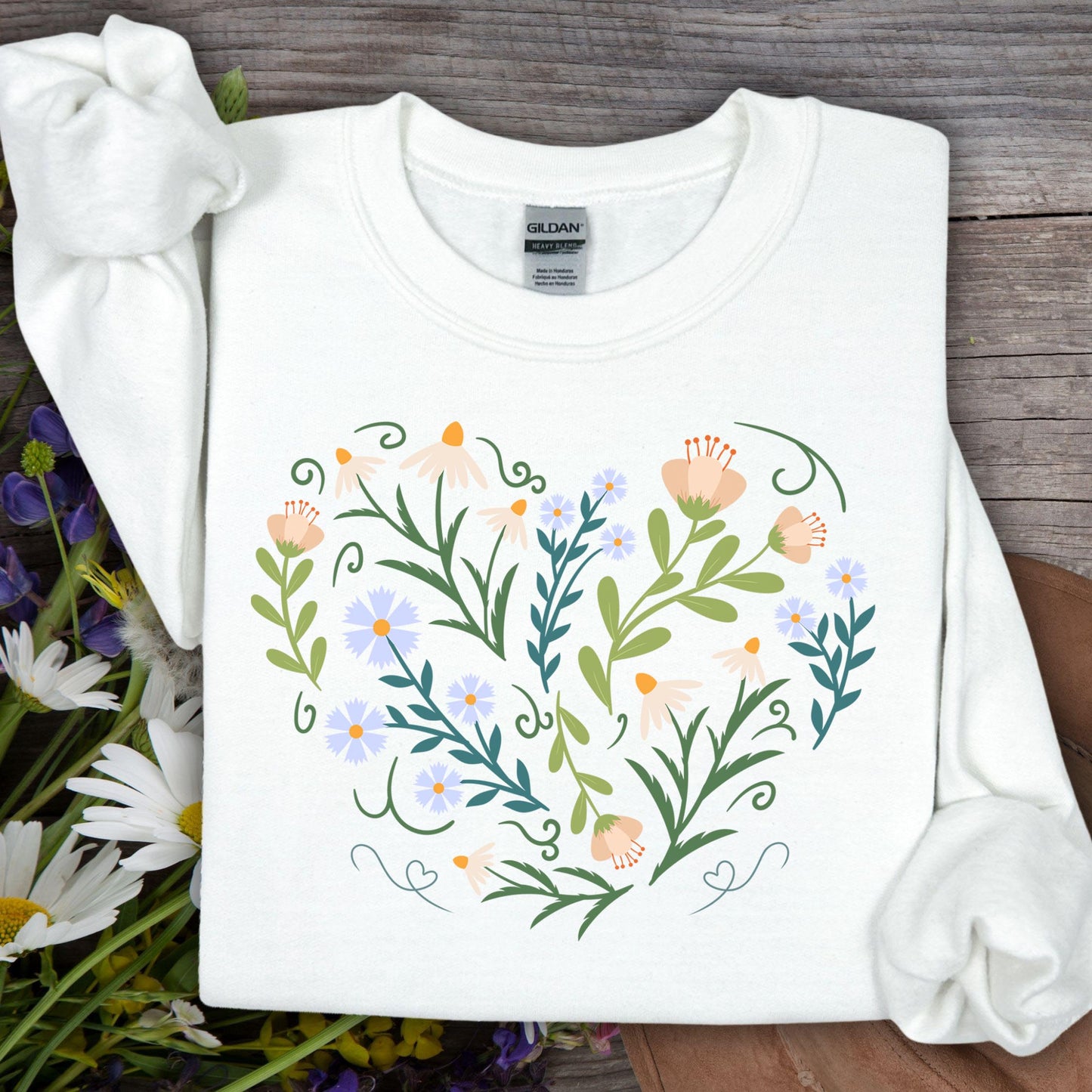 White Gildan sweatshirt with a heart-shaped botanical illustration of daisies, tulips, and vines.