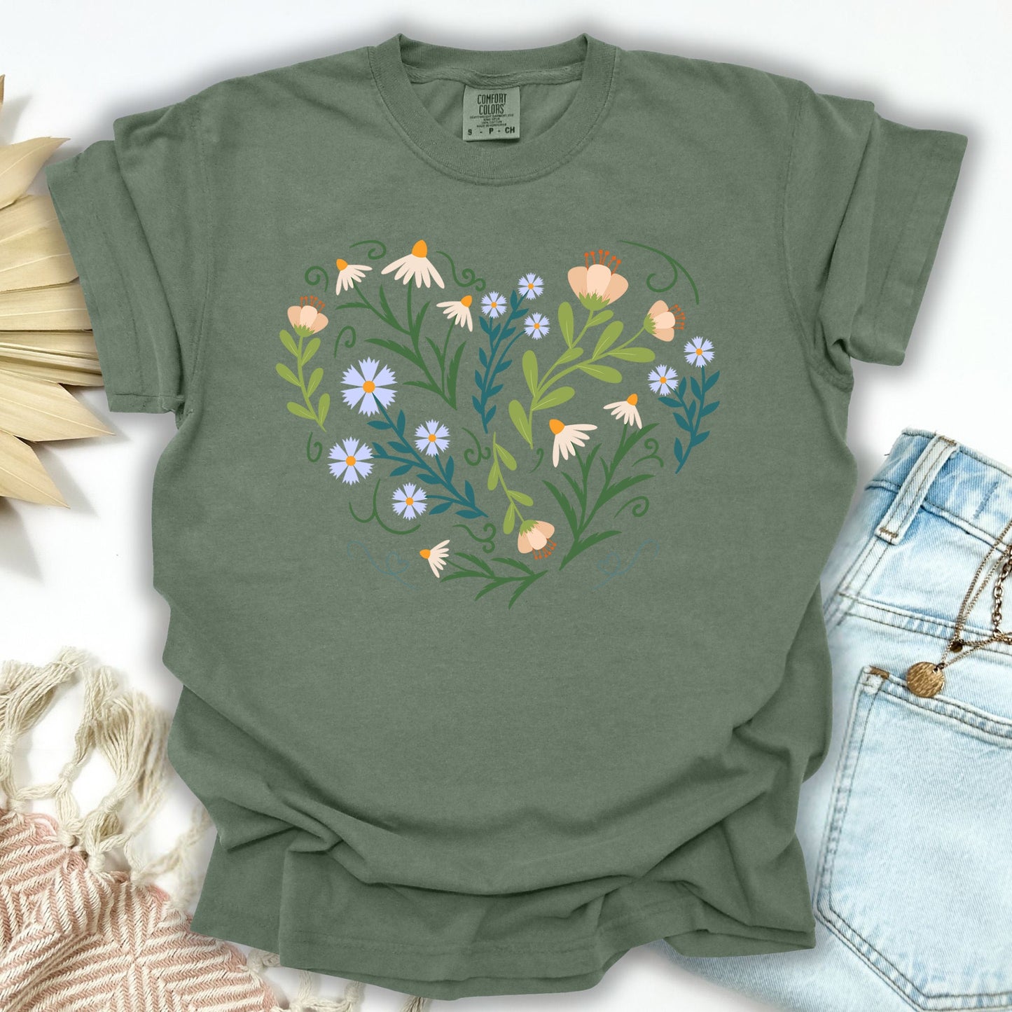 Moss S T-shirt with a heart-shaped botanical design of wildflowers, bell-shaped blooms, and green foliage.
