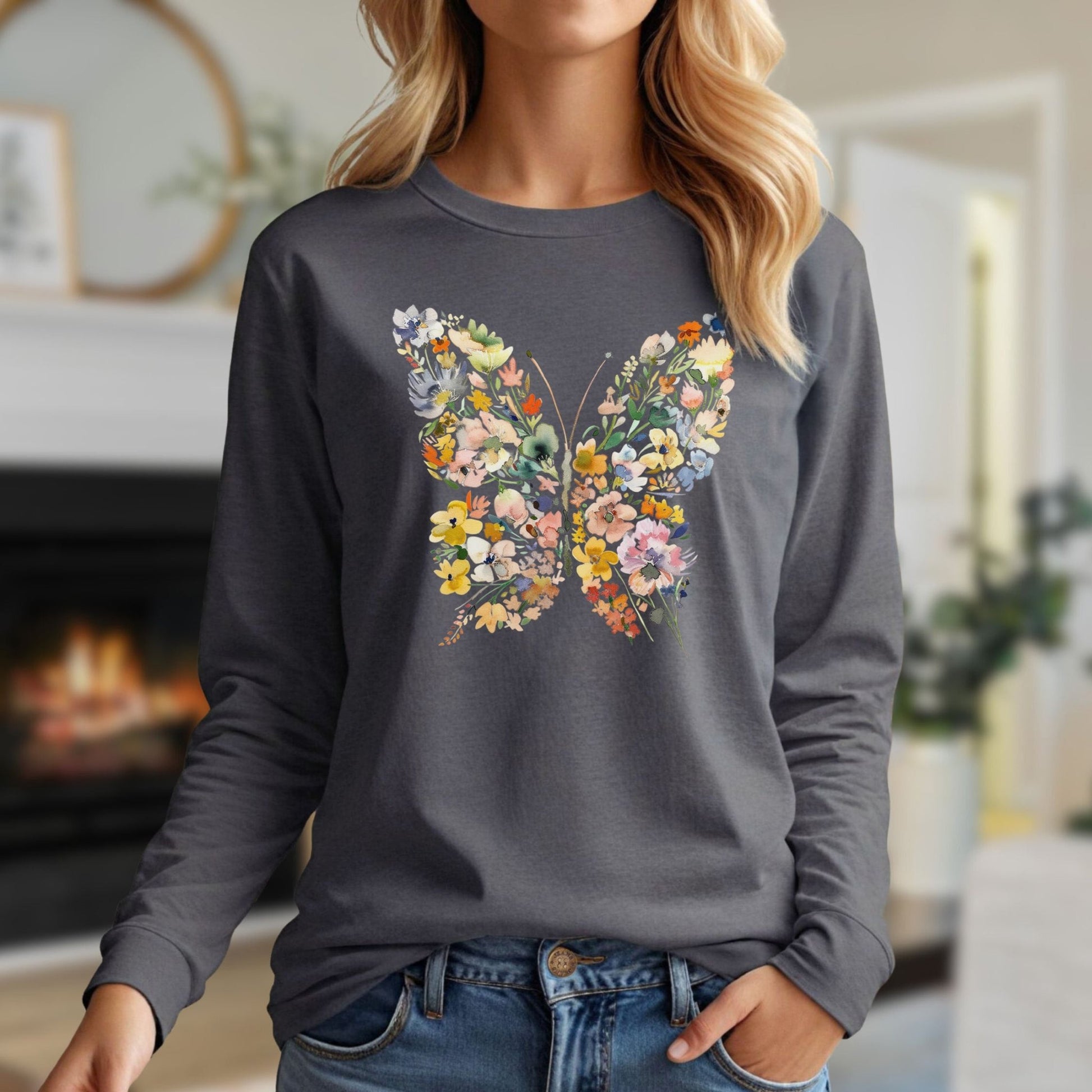 Woman in a charcoal long sleeve tee with a colorful floral butterfly design, made of 50/50 cotton-poly.